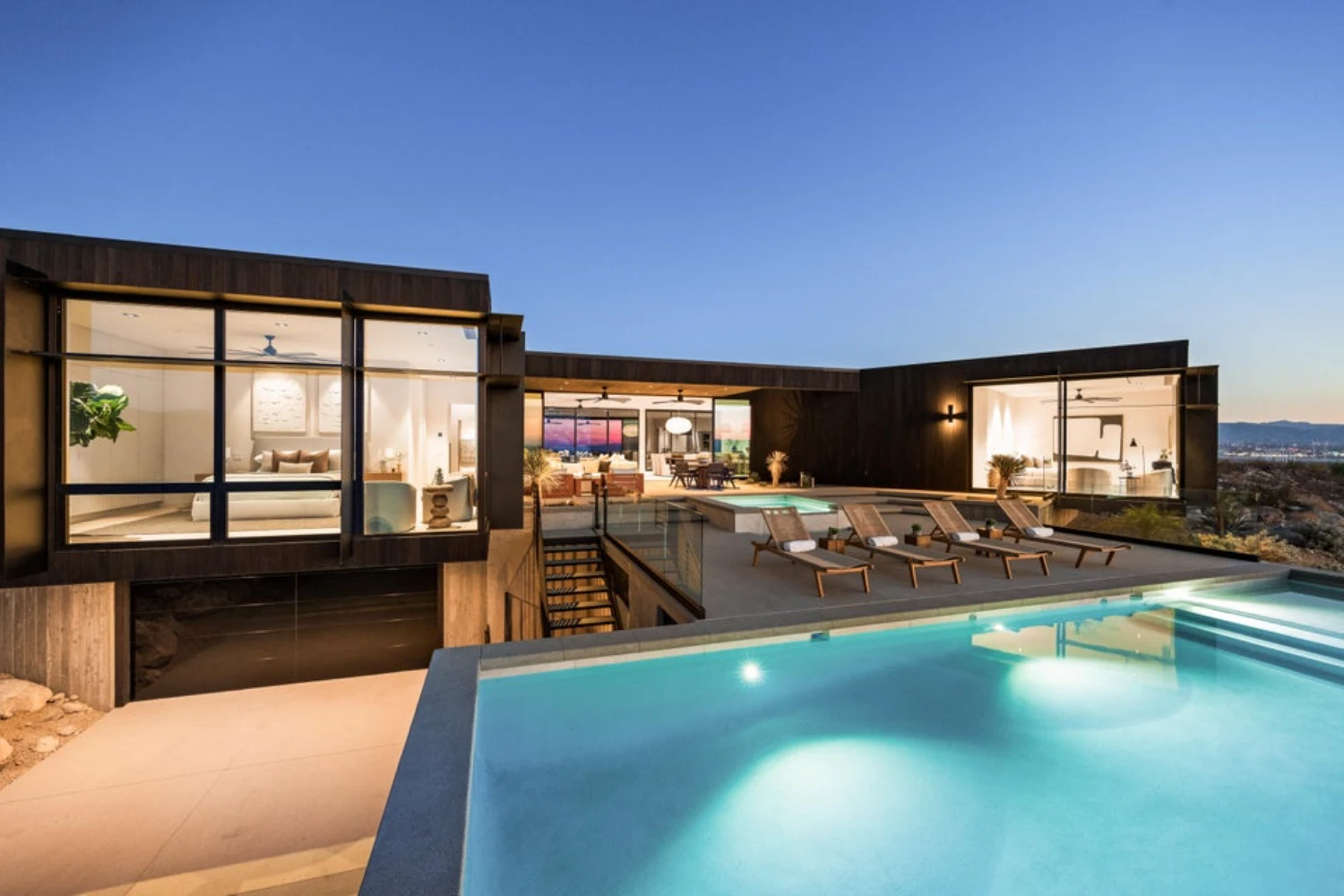 Modern luxury home in Palm Springs with expansive glass walls, contemporary architecture, outdoor living areas and a resort-style swimming pool.